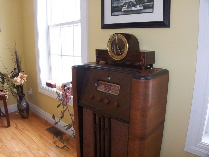 Mauthe mantel clock sitting atop a Stromberg Carlson console radio