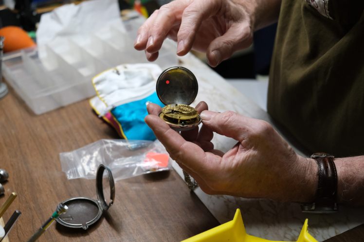 Inspecting an antique pocket watch