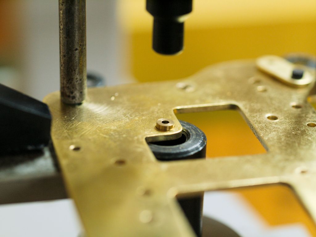 getting ready to punch a bushing into a clock plate